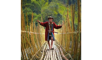 Um ancião adi caminha devagar por uma antiga ponte de bambu em Arunachal Pradesh, na Índia.