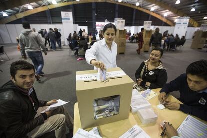 Una mujer deposita su voto en una urna en el centro de convenciones Corferia