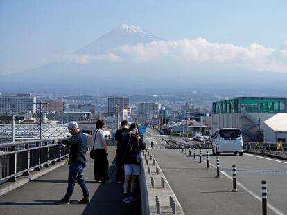 Tourists take photos on the Mount Fuji Big Dream Bridge in Japan, which has been blocked by the authorities due to excessive crowds.