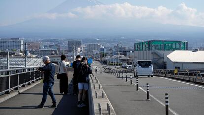 Turistas extranjeros toman fotos en el Puente del Gran Sueño del Monte Fuji, que ha sido bloqueado por autoridades por un exceso de turistas.