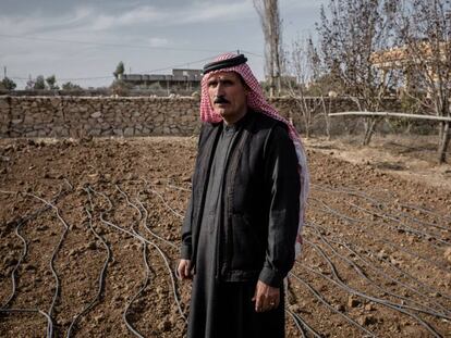 Un agricultor iraquí junto a su terreno, seco, al lado de un canal de irrigación.
