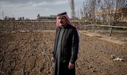 Un agricultor iraquí junto a su terreno, seco, al lado de un canal de irrigación.