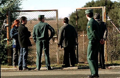 Guardias civiles y otros funcionarios en la verja de la fosa séptica donde fueron hallados los restos.