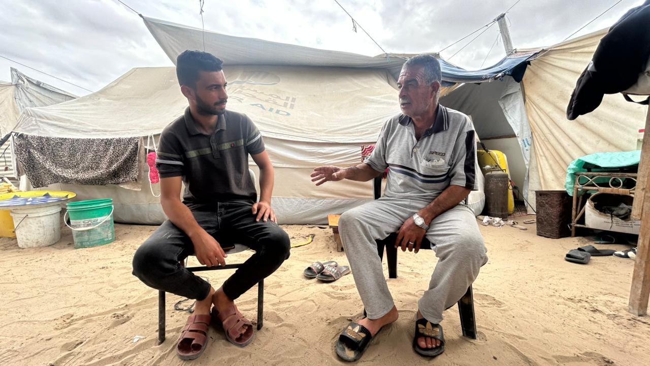 Samer Al Masry, de 63 años, empleado público jubilado, con su hijo Mohammed, de 31 años, ingeniero civil, en la tienda que comparten en Al Mawasi, Gaza, el 9 de octubre.