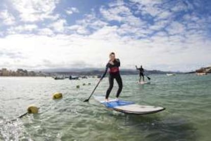 Una chica practicando paddel surf en Las Canteras.