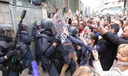 Agentes de la policía intentan evitar la entrada de votantes en un colegio en Girona.