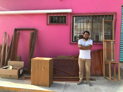 José Mervyn posa junto a unos muebles de madera en contrucción