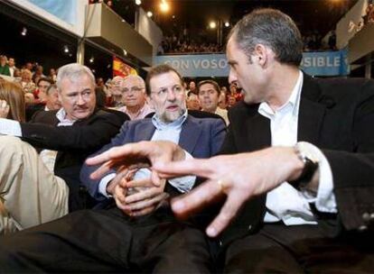 El presidente del PP, Mariano Rajoy, junto a los presidentes regionales de su partido en la Comunidad Valenciana, Francisco Camps y Murcia, Ramón Luis Valcárcel, en el acto celebrado en Elche.