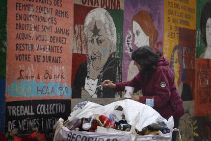 Una mujer repasa pintadas feministas vandalizadas en la barrio Gótico de Barcelona, España.