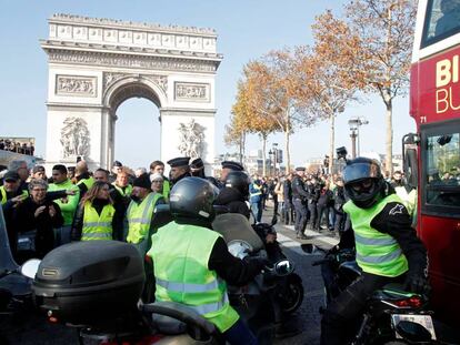 Manifestantes contra la subida de los combustibles bloquean el paso de un autobús turístico, este sábado en París.