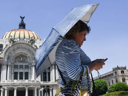 Una mujer se resguarda del sol bajo su sombrilla en Ciudad de México, el 16 de abril.