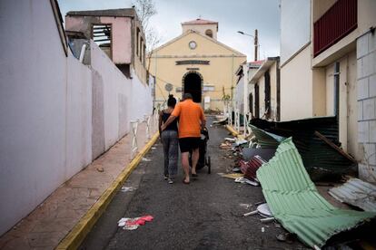 En la imagen, una pareja camina por las calles de Marigot rodeados de escombros causados por el huracán Irma, en San Martín.