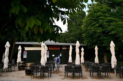 Un hombre barre la terraza de caseta del Parque de El Retiro de Madrid.