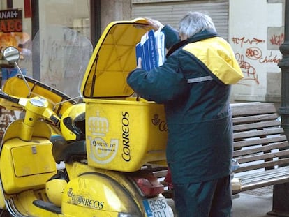 Un cartero con la moto que usa para el reparto, en una imagen de archivo.