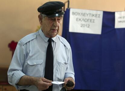 Un hombre vota en un colegio electoral en Atenas en los comicios más importantes desde la caída de la dictadura, según los definen los medios griegos.