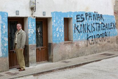 Salvador Ulayar, ante la puerta de su casa, donde ETA asesin a su padre. La pintada dice "Fuera los conquistadores espa?oles".