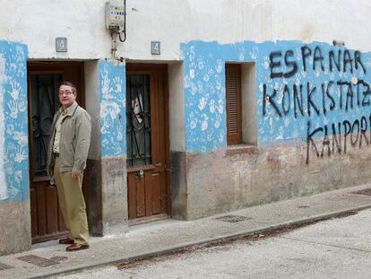 Salvador Ulayar, ante la puerta de su casa, donde ETA asesinó a su padre. La pintada dice "Fuera los conquistadores españoles".