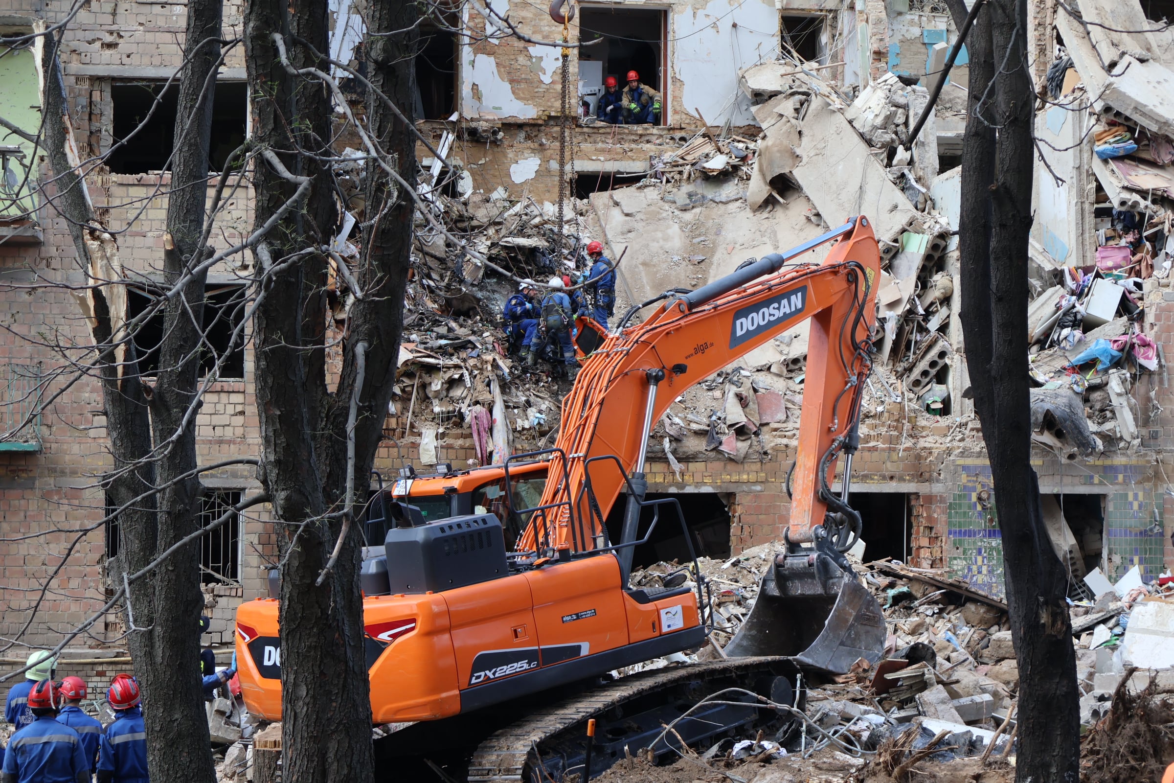 Los bomberos recuperan un cadáver en el edificio golpeado por el bombardeo.