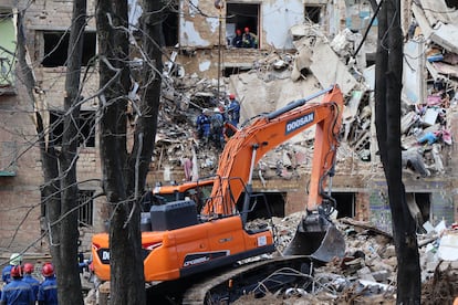 Los bomberos recuperan un cadáver en el edificio golpeado por el bombardeo.