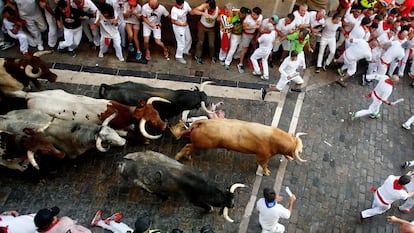 Un mozo atrapado bajo los toros de Cebada Gago durante el primer encierro de San Fermín.