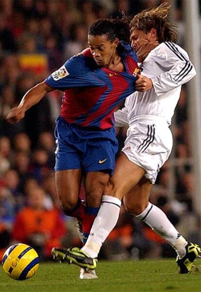 Ronaldinho no ha demostrado su gran calidad, aunque tampoco le hecho mucha falta a su equipo. En esta foto el delantero brasile?o disputa el baln con el defensa madridista Michel Salgado, quien, como todo su equipo, ha estado en un tono mediocre.