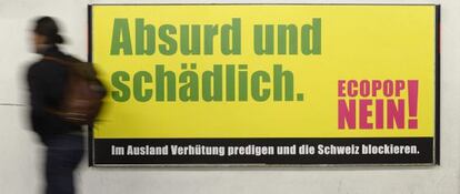 Un ciudadano de Z&uacute;rich pasa por delante de un cartel contrario a la iniciativa de Ecopop para frenar la inmigraci&oacute;n.