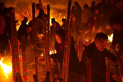 Devotos encienden incienso y papel de 'joss' durante la oración en la víspera del Año Nuevo chino, en Chongging (China), el 4 de febrero.
