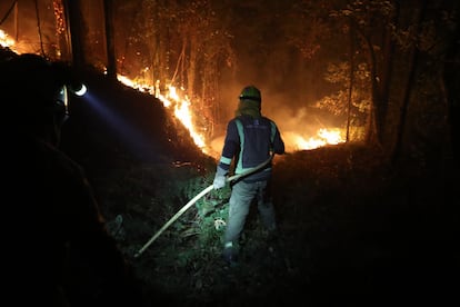 Un bombero en las labores de extinción del incendio en Barreiros, el domingo por la noche.