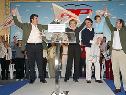 José María Aznar, con un niño en brazos, junto a Esperanza Aguirre, ayer, en un mitin de la campaña del PP.