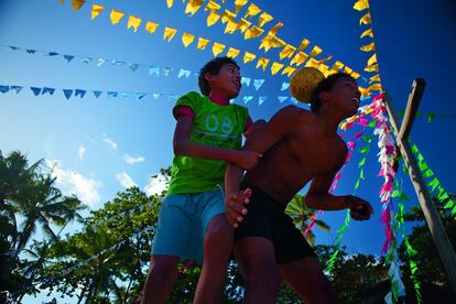 Dos niños bromean con un balón sucio de tierra en Praia do Forte, en Bahia.