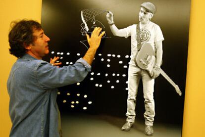 Juan Torre posa junto a la fotografía que ha realizado del músico Fito Cabrales, ayer en su muestra en Bilbao.