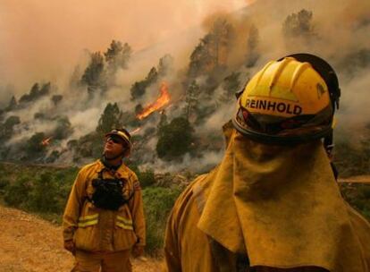 Un par de bomberos observan las llamas en la localidad de Briceburg, California