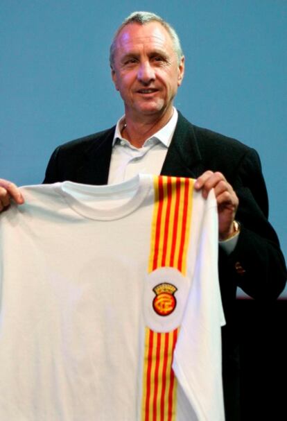 El ex futbolista holandés Johan Cruyff posa con una réplica de la camiseta de la selección de Cataluña de fútbol con la que él mismo jugó en 1976 durante el acto de presentación del holandés como nuevo técnico de la selección catalana.