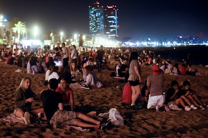 Varias personas celebran en la playa de la Barceloneta la noche de San Juan el 24 de junio.