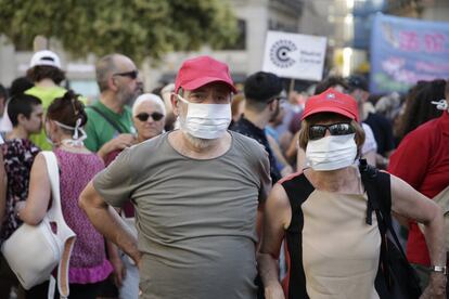 Dos manifestantes asisten con mascarillas a la marcha en el centro de la capital.