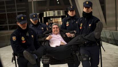 Un miembro de la Plataforma de Afectados por la Hipoteca es sacado por la policía tras haber entrado en la sede centra de Bankia.