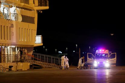 Personal médico traslada hacia una ambulancia a un pasajero del Greg Mortimer, el viernes 10 de abril.