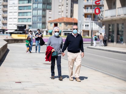 Varias personas pasean por el Paseo Marítimo de Sanxenxo, en Pontevedra, Galicia (España).