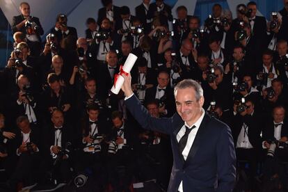 El director francés Olivier Assayas, posa con su trofeo durante una sesión de fotos después de ser galardonado con el premio al mejor director por la película 'Personal Shopper' en el 69º Festival de Cannes.