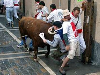 Primer encierro de los Sanfermines, un toro corneando a corredores