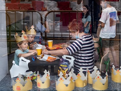 Clientes con coronas de papel en la cadena estadounidense de restaurantes de comida rápida de hamburguesas Burger King en España