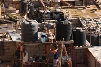 Dos hombres rellenaban el viernes los depósitos de agua de una vivienda en Rafah, en el sur de la Franja. 