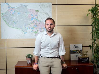 Alberto Escribano, alcalde de Arganda del Rey, junto a un mapa de la localidad, situado en su despacho del Ayuntamiento; en el mapa, la zona rosa son las viviendas y la gris, el polígono industrial.
