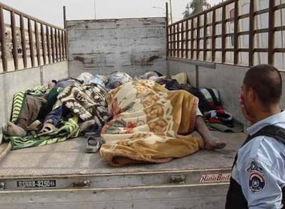 Un policía iraquí observa los cuerpos de víctimas de la violencia en Mahmudiya, sur de Bagdad, el pasado lunes.