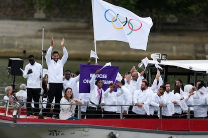 El equipo Olímpico de Refugiados saludan durante el desfile de las delegaciones por el río Sena.