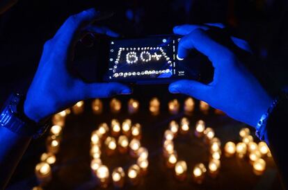 Un hombre de Sri Lanka realiza una fotografía a unas velas durante el apagado de las luces, en la ciudad de Colombo.