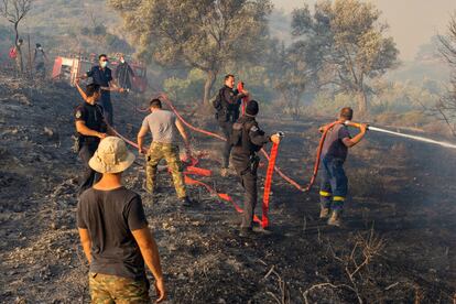 Bomberos y voluntarios colaboran para apagar las llamas cerca de Asklipio (Grecia), este lunes.