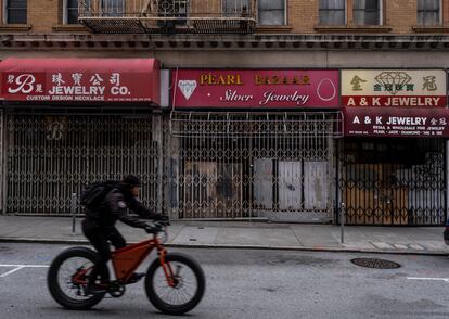 A man cycles past several closed stores in San Francisco's Chinatown neighborhood on May 24.