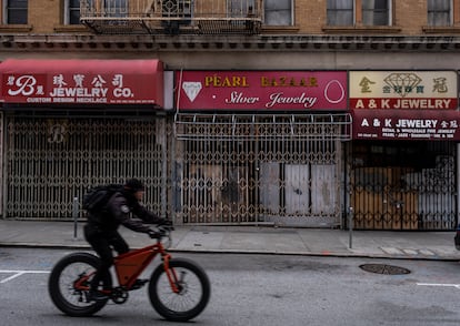 A man cycles past several closed stores in San Francisco's Chinatown neighborhood on May 24.