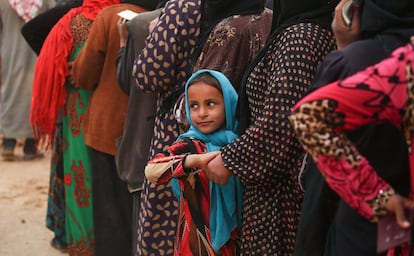 A displaced Syrian child, who fled the countryside surrounding the Islamic State (IS) group stronghold of Raqa, looks on as she stands in a queue at a temporary camp in the village of Ain Issa on April 28, 2017. / AFP PHOTO / DELIL SOULEIMAN